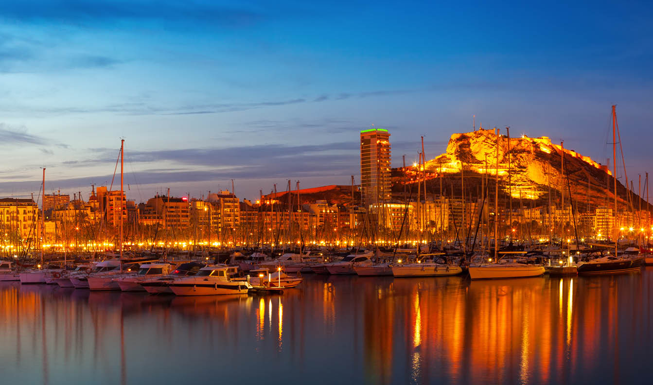 Panorama of port with yachts against cityspace and Castle of Santa Barbara in night  Alicante, Spain
